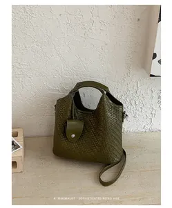 Detalle del bolso tipo cubo trenzado verde oliva con diseño retro minimalista