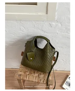 Detalle del bolso tipo saco trenzado verde oliva con superficie texturizada y estilo retro