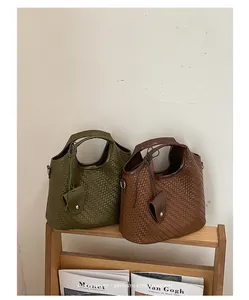 Vista detallada de bolsos tipo cubo trenzados en colores verde retro y marrón café