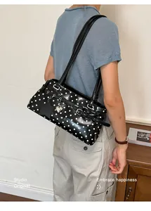 Stylish black and white polka dot underarm shoulder bag with a silver heart charm.