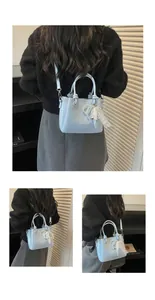 Bolso bombonera azul claro con textura tejida y elegante adorno de encaje y perlas.