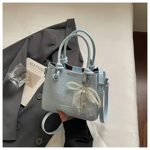 Bolso tipo cubo tejido azul claro con lazo de perlas y correa ajustable para mujer