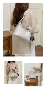 Vista composita con varie angolazioni di una borsa sottobraccio bianca minimalista.