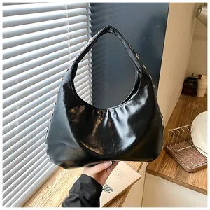 Detailed close-up view of a vintage black hobo bag featuring stylish silver rivet accents.