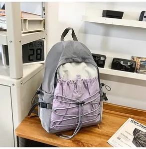 Grauer und lila Wanderrucksack für Outdoor-Aktivitäten auf einem hölzernen Schreibtisch