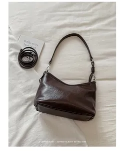 Elegante borsa sottobraccio minimalista marrone scuro con tracolla extra e libro decorativo