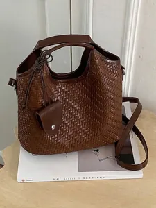 Elegante bolso de hombro tipo cubo tejido en color marrón con correa ajustable
