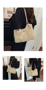 Detalle de bolso tote vintage beige con colgante de oveja y correas marrones.