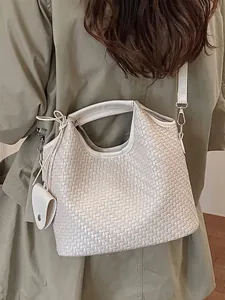 Bolso de cubo tejido beige elegante para mujer con correa ajustable mostrado en modelo