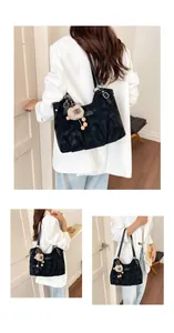 Modelo con un bolso tote vintage negro de gran capacidad y llavero de oso de peluche.