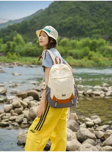Japanese minimalist color-block student backpack shown in a scenic outdoor river setting