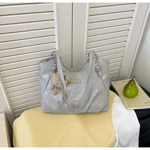 Bolso tote plateado vintage presentado sobre un tejido de punto de color amarillo