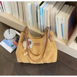 Vista detallada del bolso tote vintage amarillo con un lindo colgante de oveja y correas