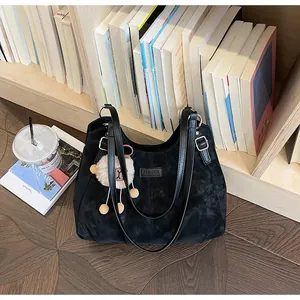 Vista detallada del bolso tote vintage de ante negro con charm de peluche para oficina