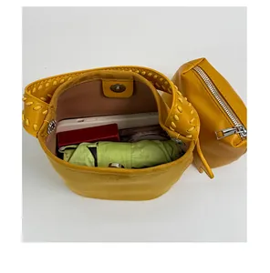 Détail montrant l'intérieur spacieux du sac seau jaune avec les objets du quotidien.