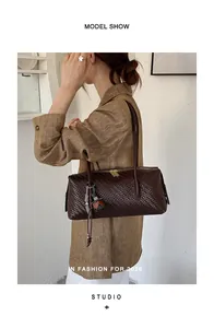 Elegant brown woven pillow shoulder bag worn by model in a minimalist studio setting