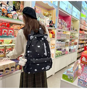 Μαύρη τσάντα πλάτης με αυτιά γάτας και αστέρια σε ένα μοντέρνο περιβάλλον αγοράς.