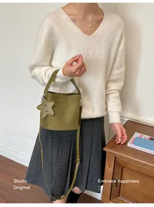 Détail d'un sac seau en daim vert avec breloque étoile et bandoulière réglable