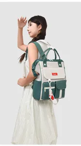 Detailed side view of large green and beige nylon backpack carried by a female model
