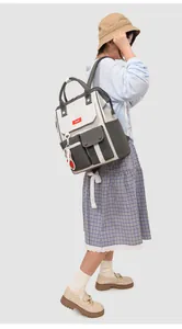 Side view of a female model wearing the large capacity nylon backpack in grey