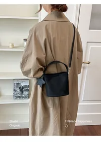 Sac seau noir minimaliste pour le trajet avec poignée tressée et breloque étoile