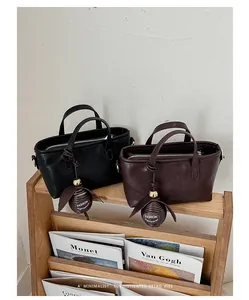 Détail de petits sacs à main minimalistes pour femmes en noir et marron foncé chic.