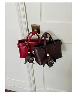 Vue détaillée de deux mini sacs rétro rouges et café suspendus à une poignée de porte.