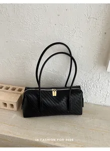 Elegante retro zwarte geweven schoudertas met lange banden en goudkleurige ritsen.