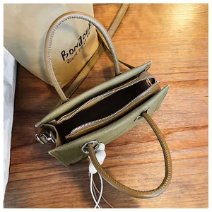 Draufsicht auf olivgrüne Retro-Handtasche mit geräumigen Innenfächern und Reißverschluss.