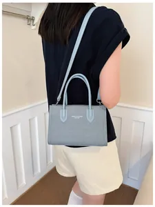 Elegante hellblaue Vintage-Handtasche für Damen, stilvolle Umhängetasche an einem Model