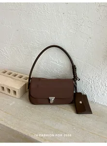 Elegante borsa baguette in pelle marrone scuro con tracolla intrecciata e pochette abbinata