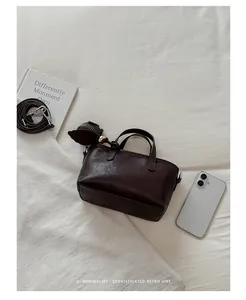 Élégante vue de dessus d'un sac à main minimaliste marron foncé sur un tissu blanc