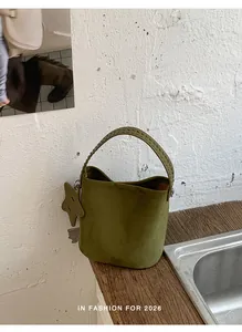 Sac seau vert olive moderne avec poignée tressée et breloque étoile en décor lifestyle