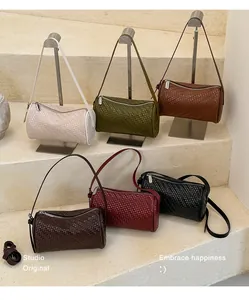 Selection of stylish woven texture cylinder bags in six classic colors displayed on stands.