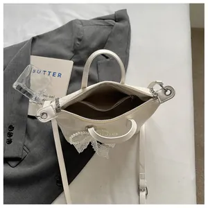 Detailed interior view of white textured tote bag with an elegant pearl lace charm