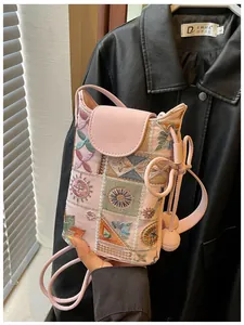 Gros plan sur les broderies chinoises traditionnelles sur un mini sac seau rose