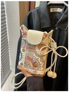 Détail du mini sac seau crème avec broderie de style chinois et motifs floraux