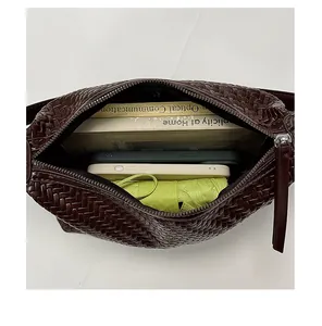 Interior view of brown woven bag showing capacity for books, phones and umbrella