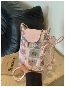 Gros plan exquis du mini sac bandoulière brodé de style chinois en rose tendre