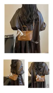 Macro view of vintage brown textured tote bag with lace ribbon and chain details.