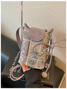 Gros plan sur un mini sac seau violet orné d'une broderie florale chinoise complexe.