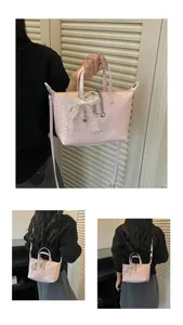 Detailed view of a pink woven tote bag featuring a lace bow and chic chain accents