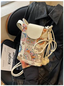 Gros plan d'un mini sac seau blanc avec une broderie chinoise traditionnelle vive