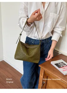 Detailed view of the olive green woven texture on a stylish women's underarm shoulder bag.