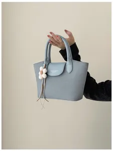 Close-up detail of light blue vintage handbag for women with cute flower charm accessory