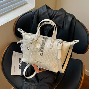 Detailed macro view of off-white woven commuter tote bag with pearl and lace decorations