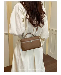 Stijlvol model met een verfijnde bruine retro crossbody tas in een crème-omgeving