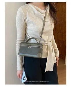 Verfijnde olijfgroene boxtas gestyled met een minimalistische top en zwarte broek
