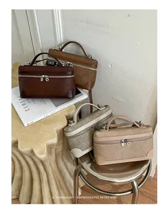 Vier vintage handtassen in aardetinten gepresenteerd op een stijlvolle stoel.
