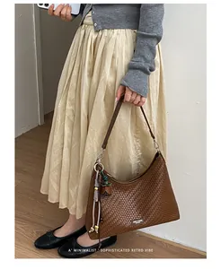 Vista dettagliata di una borsa a tracolla intrecciata marrone con stile retrò minimalista